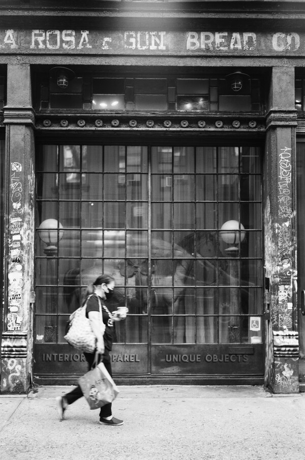 Woman walking in front of old building