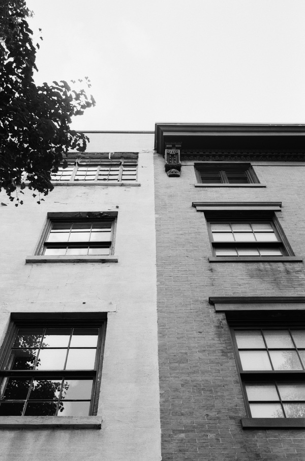 Two brick buildings next to each other, one lighter and one darker