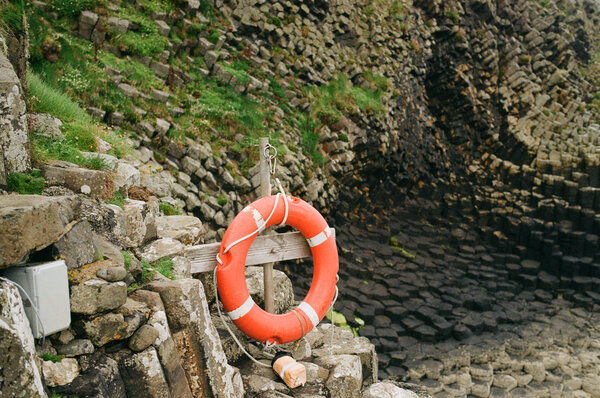 Life preserver in front of rocks